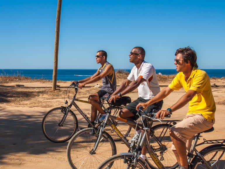 Liten cykelgrupp intill stranden